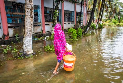 A woman collects essential relief items from an ActionAid distribution point in Noakhali Sadar District. 